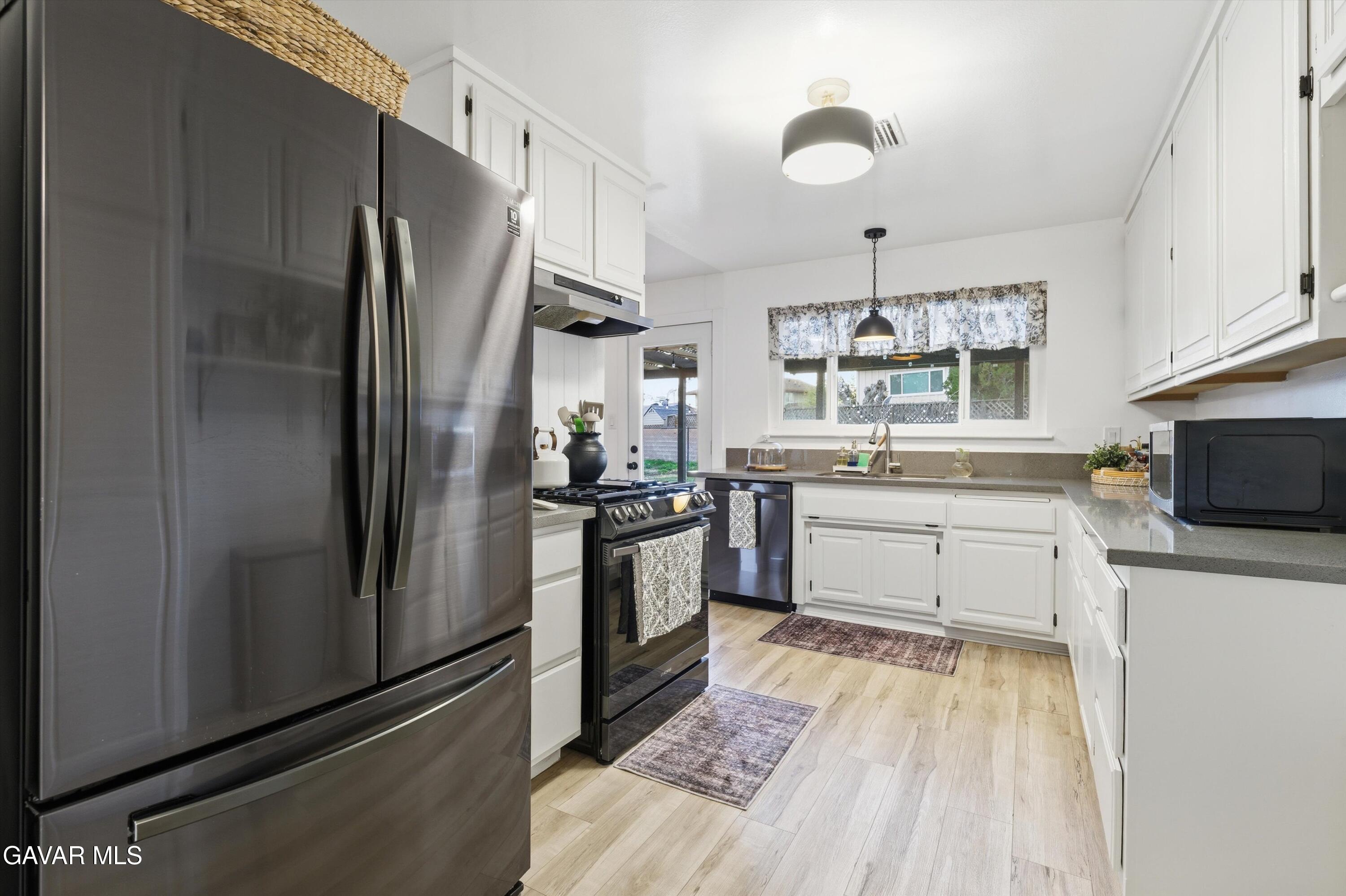 43851 Fern Avenue Lancaster, CA 93534 - Photo 4 of 20 a kitchen with stainless steel appliances a refrigerator sink and microwave