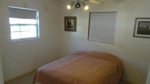 a view of a bedroom with a bed and a window