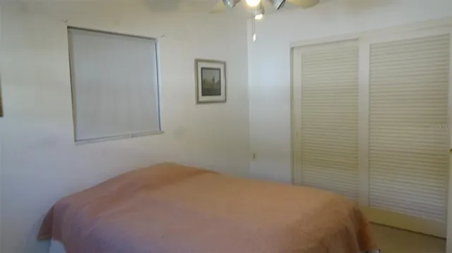 a bedroom with a bed and a chandelier fan
