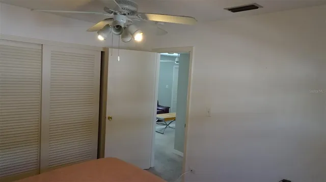 a bathroom with a shower and a ceiling fan