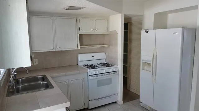 a kitchen with white cabinets and white appliances