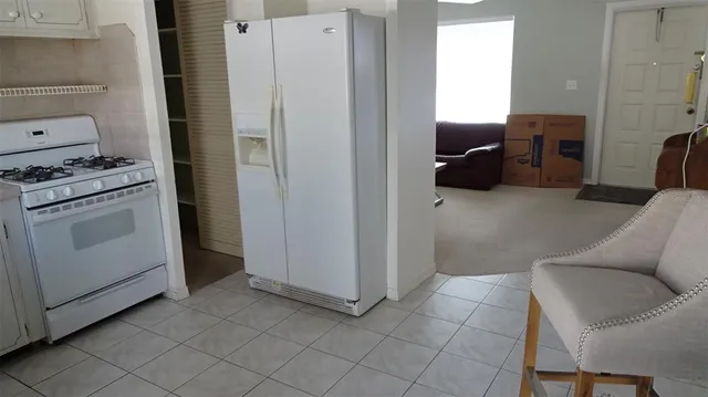 a view of kitchen with furniture and refrigerator