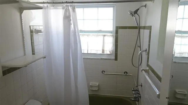 a bathroom with a window shower and vanity