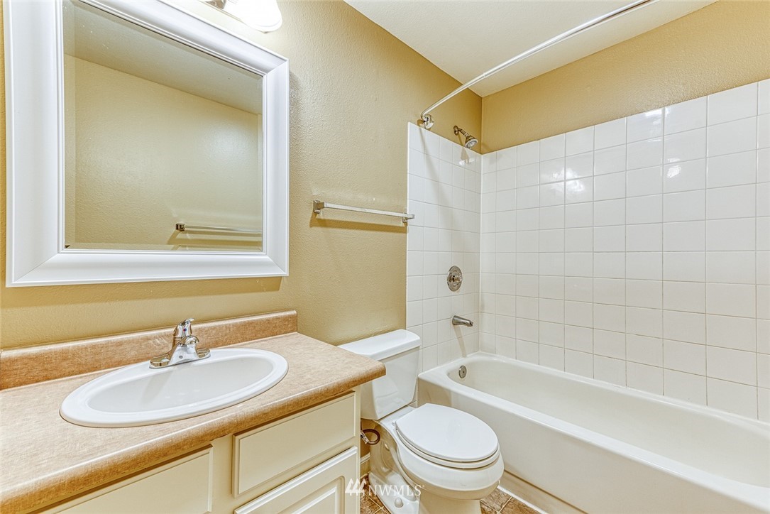 10831 Northeast 147th Lane, Unit R104 Bothell, WA 98011 - Photo 13 of 15 a bathroom with a bathtub shower sink vanity mirror and toilet