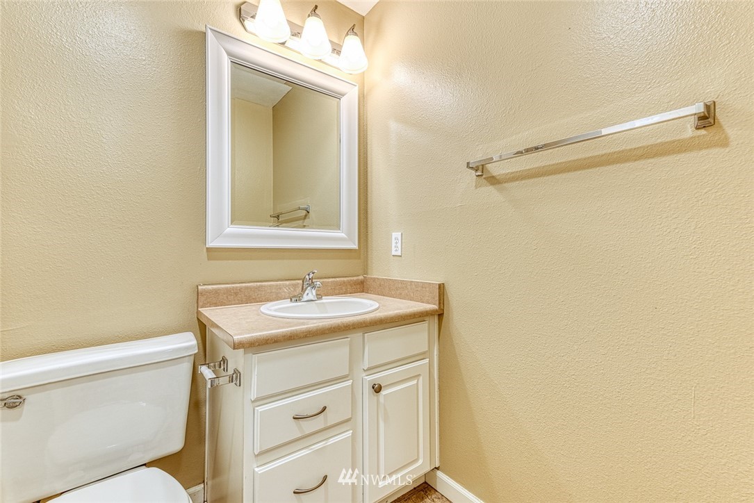 10831 Northeast 147th Lane, Unit R104 Bothell, WA 98011 - Photo 14 of 15 a bathroom with a sink a toilet and a mirror