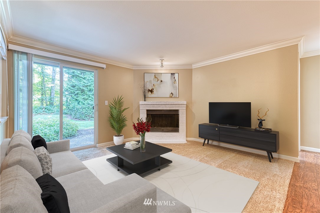 10831 Northeast 147th Lane, Unit R104 Bothell, WA 98011 - Photo 3 of 15 a living room with furniture a flat screen tv and a fireplace