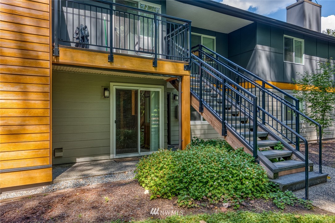 10831 Northeast 147th Lane, Unit R104 Bothell, WA 98011 - Photo 7 of 15 a view of a house with a large windows stairs and a potted plant