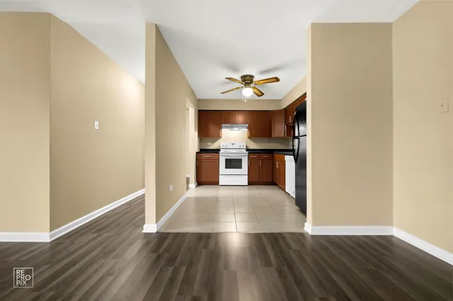 a view of a kitchen with wooden floor and a ceiling fan