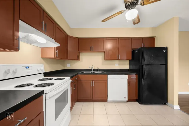 a kitchen with a refrigerator a stove and a sink