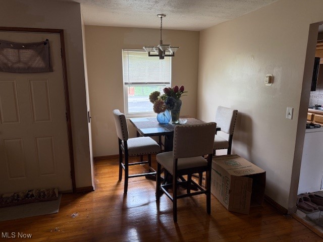 15513 Rockside Road Maple Heights, OH 44137 - Photo 5 of 11 Dining space with a chandelier, a textured ceiling, and wood finished floors