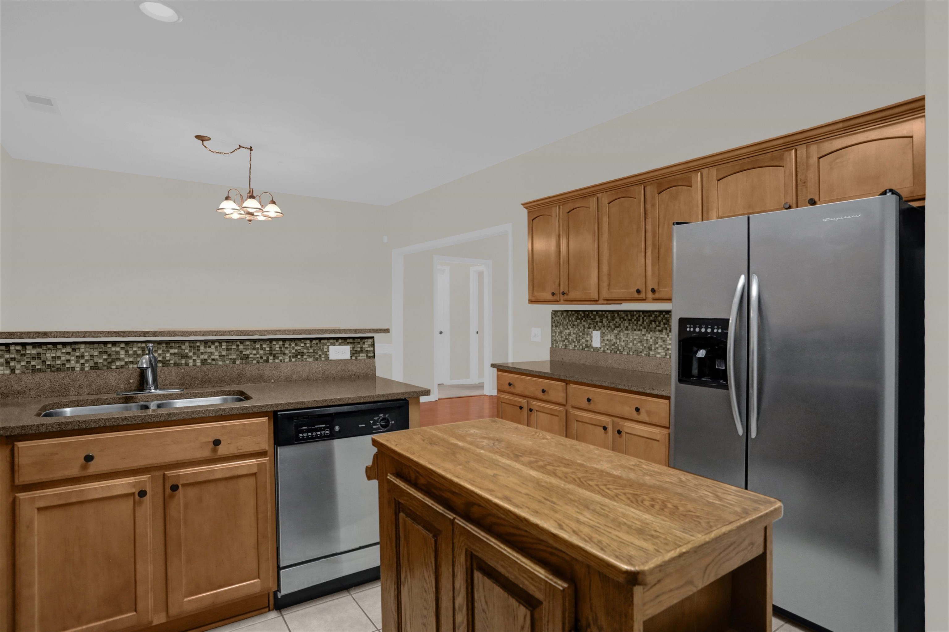 34 Peyton Ridge Drive, Unit 21 Collierville, TN 38017 - Photo 16 of 37 Kitchen featuring wood cabinetry, stainless steel appliances, a center island with a wood countertop, a mosaic tile backsplash, and recessed lighting