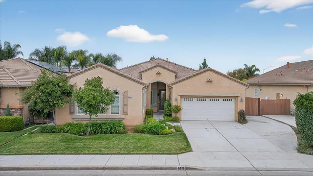 a front view of a house with a yard and potted plants