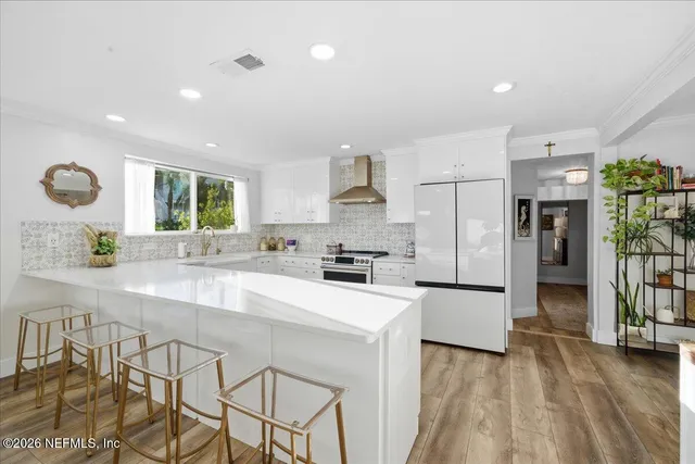 a large kitchen with kitchen island a large counter top space a sink stainless steel appliances and cabinets