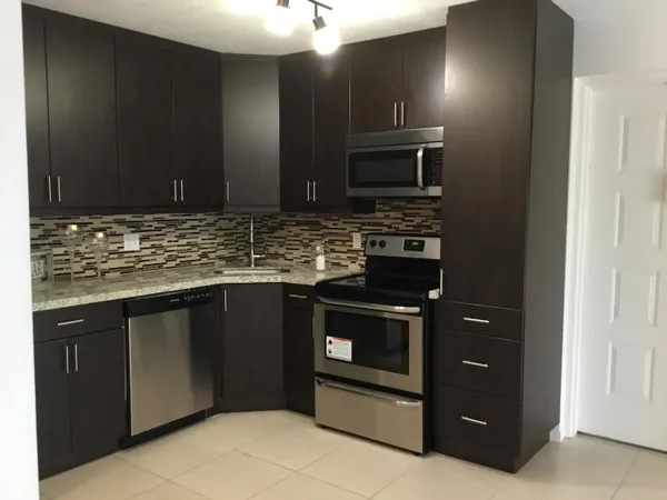 a kitchen with stainless steel appliances granite countertop a stove and a microwave