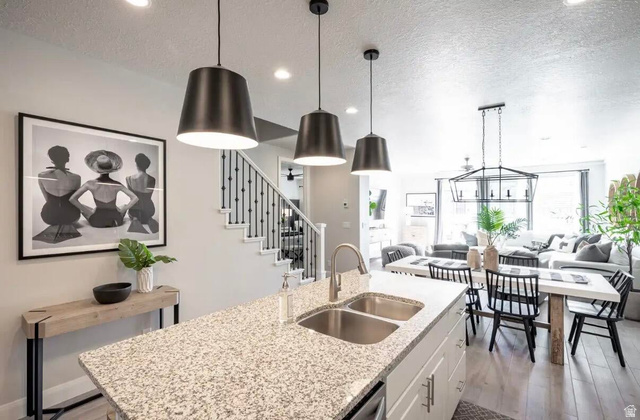 4846 Fishers Is Way St. George, UT 84770 - Photo 3 of 13 Open-concept living space featuring a kitchen island with a granite countertop and dual stainless steel sinks