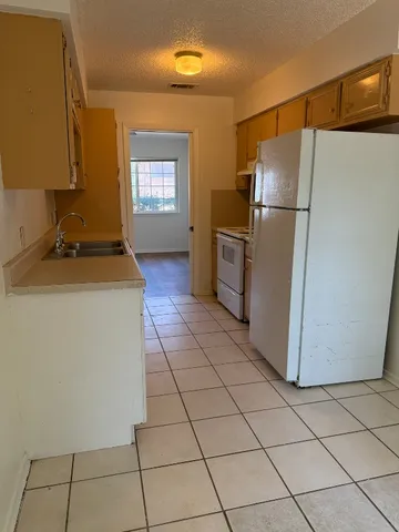 a kitchen with a refrigerator a stove top oven and a counter top space