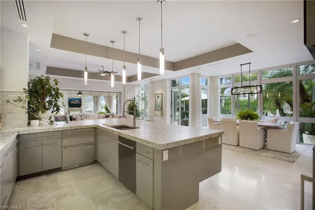a large white kitchen with a large window and sink