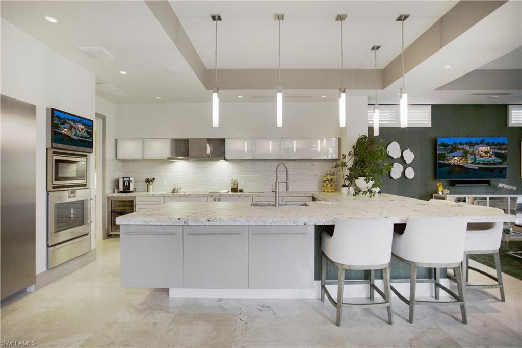2290 Tarpon Road Naples, FL 34102 - Photo 23 of 50 a kitchen with stainless steel appliances kitchen island granite countertop a sink and cabinets