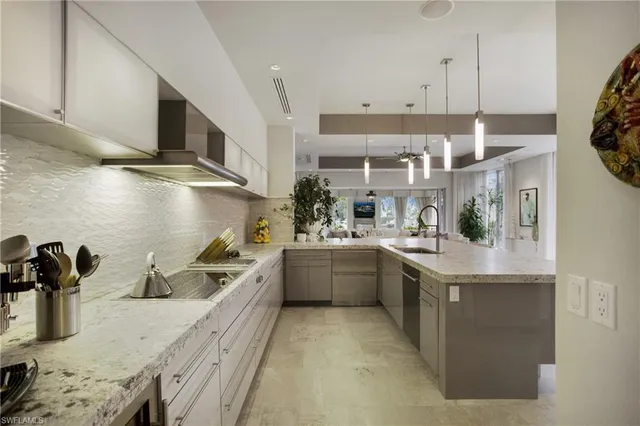 a kitchen with stainless steel appliances granite countertop a sink a stove and a refrigerator