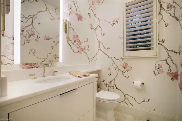 a bathroom with a sink and mirror with toilet