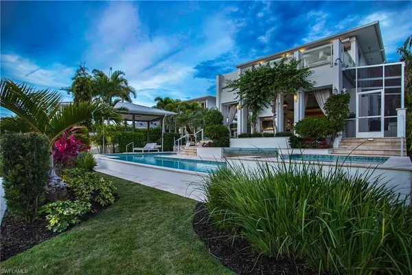 a view of a house with a yard and potted plants
