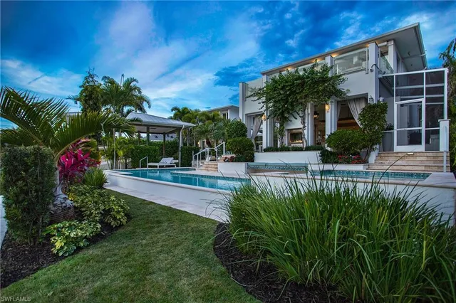 a view of a house with a yard and potted plants