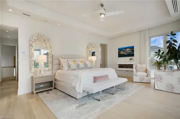 a bedroom with a large bed and a chandelier