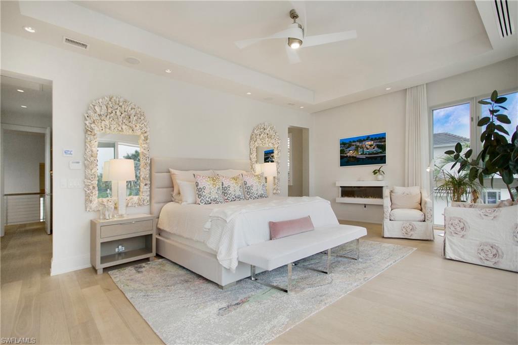 2290 Tarpon Road Naples, FL 34102 - Photo 41 of 50 a bedroom with a large bed and a chandelier