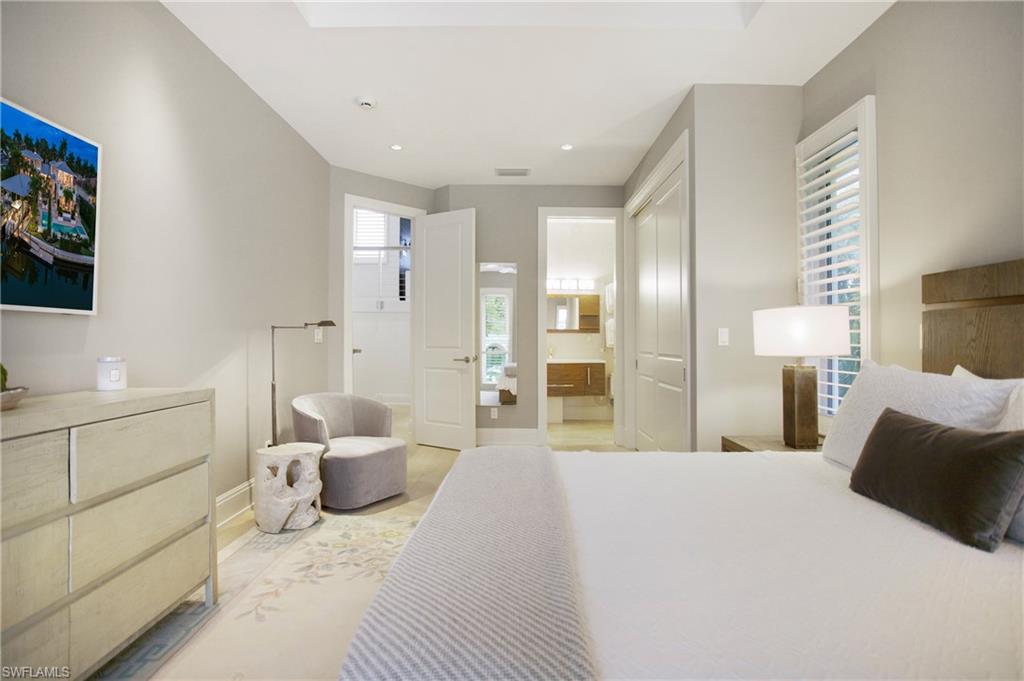 2290 Tarpon Road Naples, FL 34102 - Photo 48 of 50 a spacious bedroom with a bed a couch and a flat screen tv