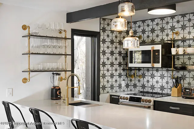 a kitchen with stainless steel appliances kitchen island granite countertop a refrigerator and a stove top oven