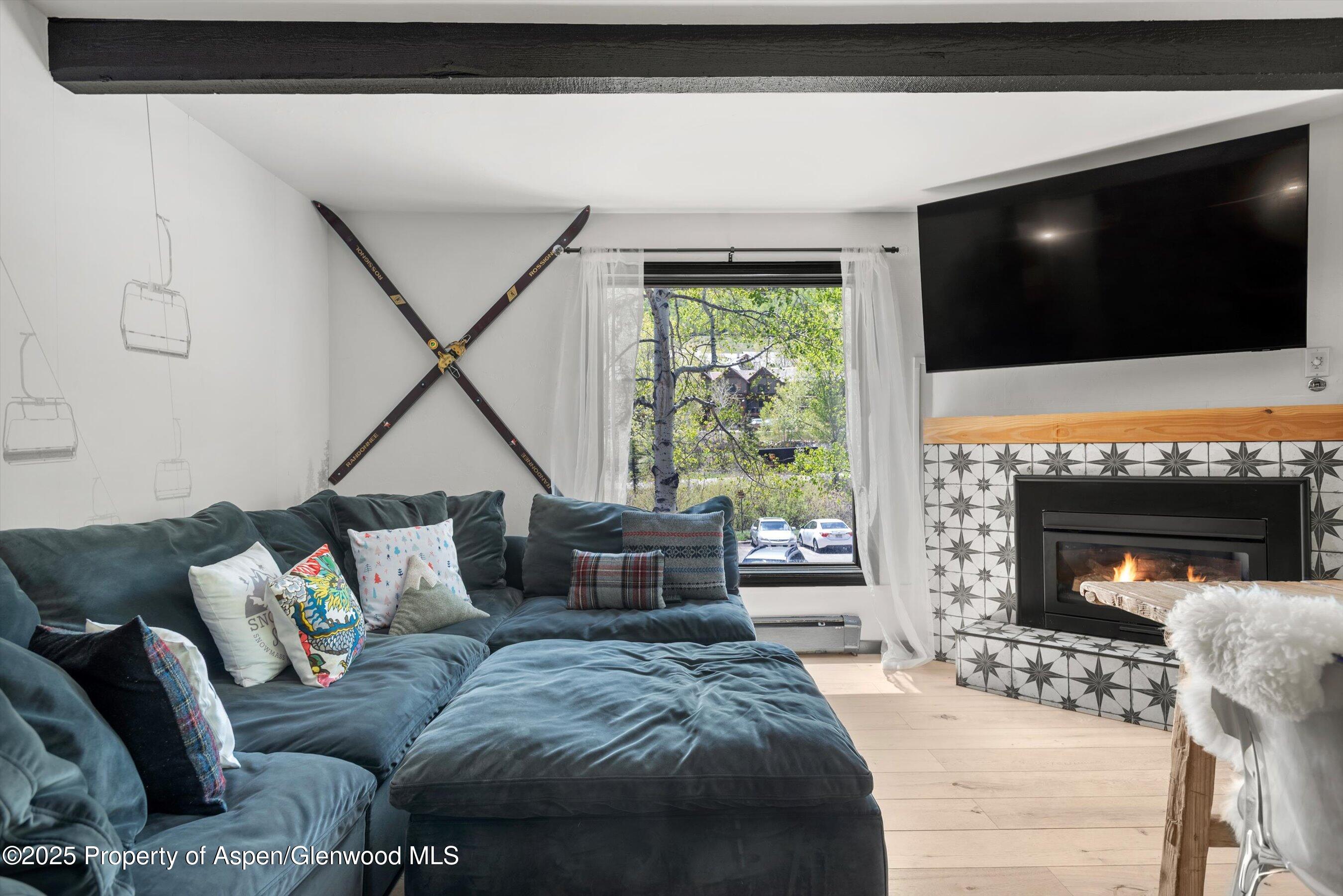 35 Upper Woodbridge Road, Unit 2A Snowmass Village, CO 81615 - Photo 8 of 29 a living room with furniture a flat screen tv and a fireplace