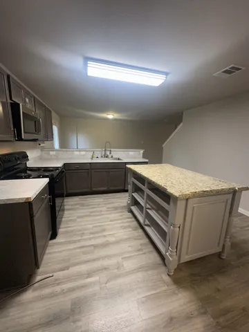 a kitchen with stainless steel appliances granite countertop a stove a sink and a refrigerator