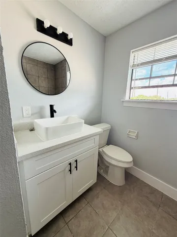 a bathroom with a toilet a sink and mirror