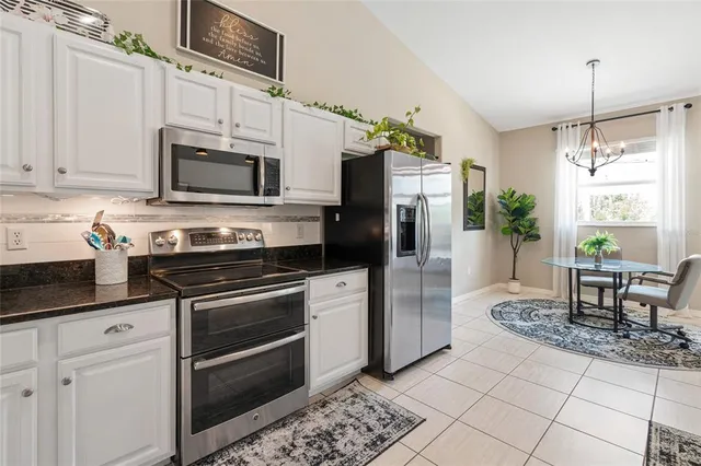 a kitchen with stainless steel appliances granite countertop a stove a refrigerator and a microwave