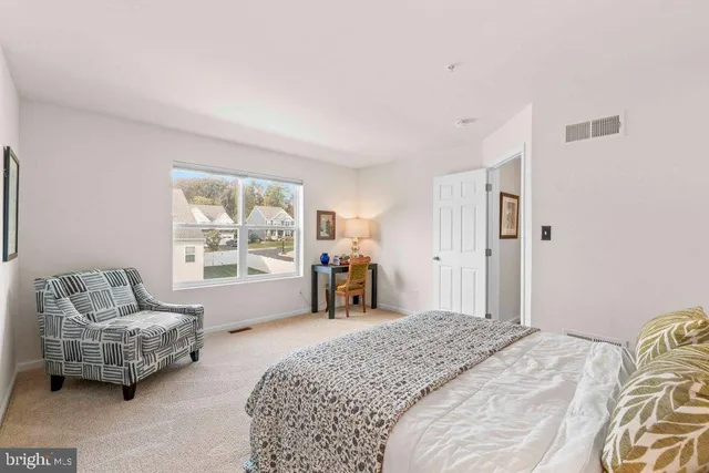 a bedroom with bed and furniture with large window