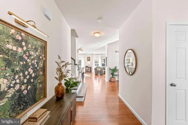 a hallway with wooden floor a clock and a large window
