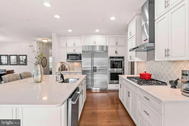 a kitchen with stainless steel appliances kitchen island granite countertop a sink and cabinets