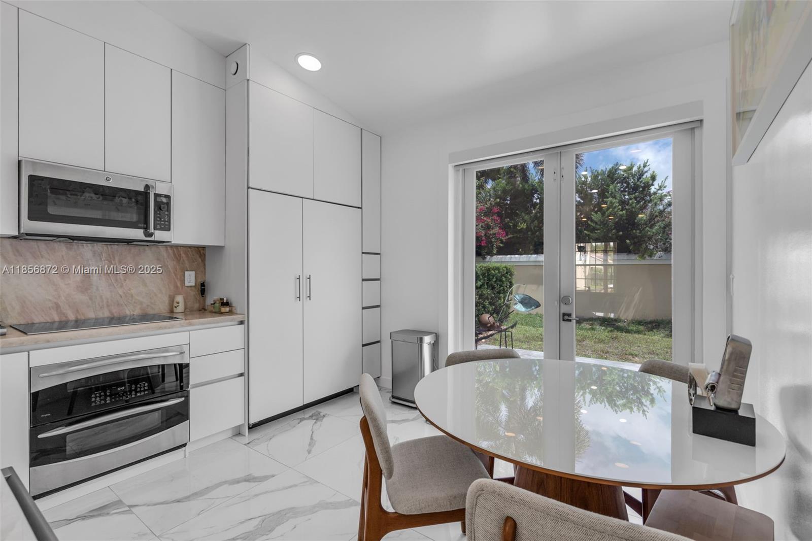 18801 Southwest 25th Court Miramar, FL 33029 - Photo 34 of 41 a dining table chair next to a window with kitchen view