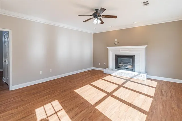 a view of a livingroom with wooden floor and a fireplace