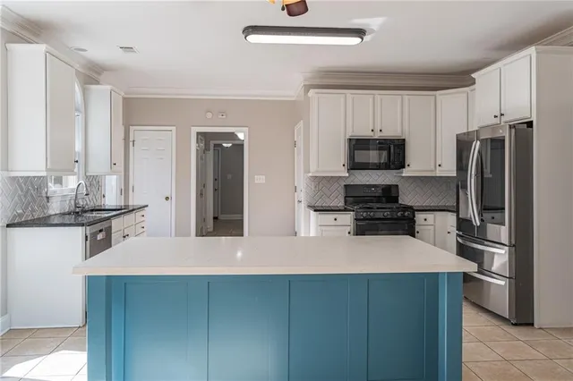 a kitchen with white cabinets and appliances