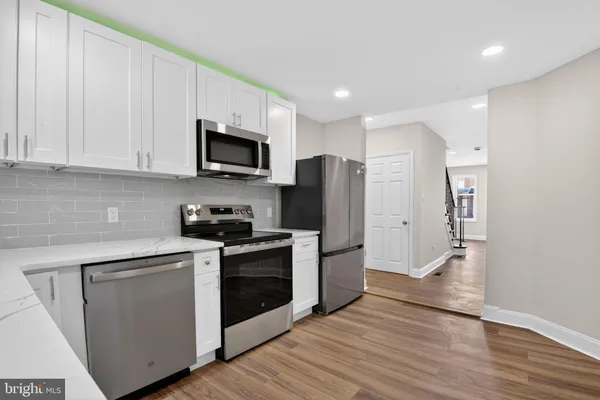 a kitchen with stainless steel appliances granite countertop grey cabinets a stove a sink and dishwasher