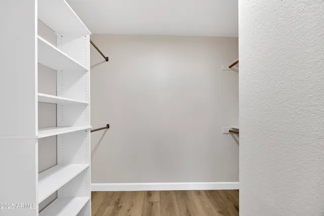 a view of walk in closet with empty racks