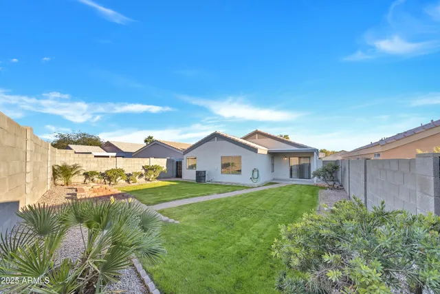 a view of a big house with a big yard and large trees
