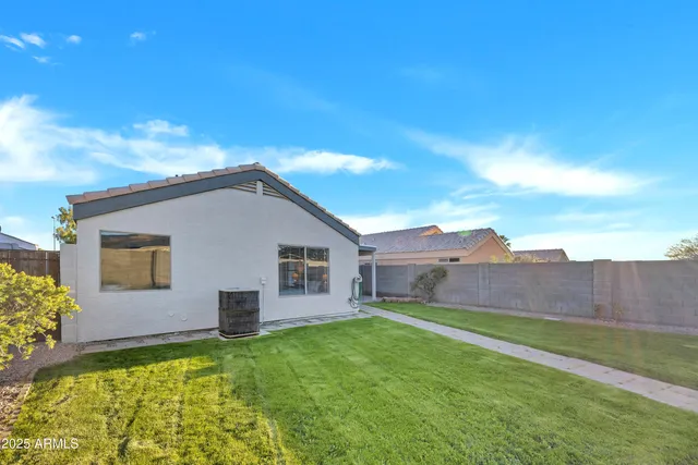 a backyard of a house with table and chairs