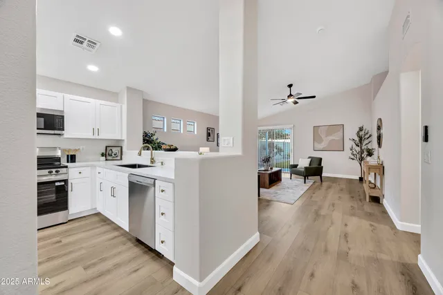 a kitchen with white cabinets and stainless steel appliances