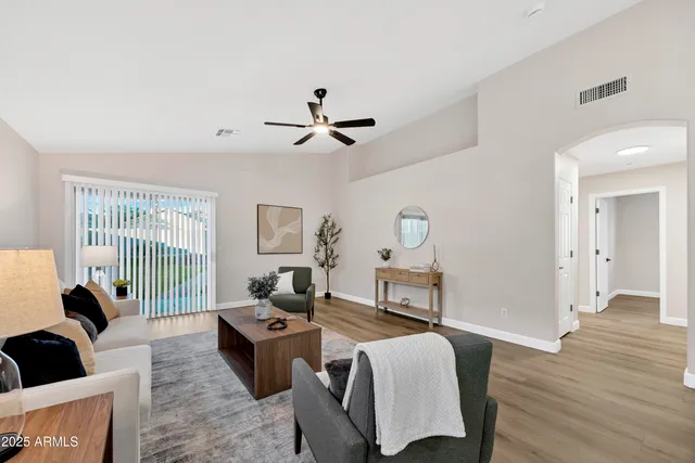 a living room with furniture a ceiling fan and a window