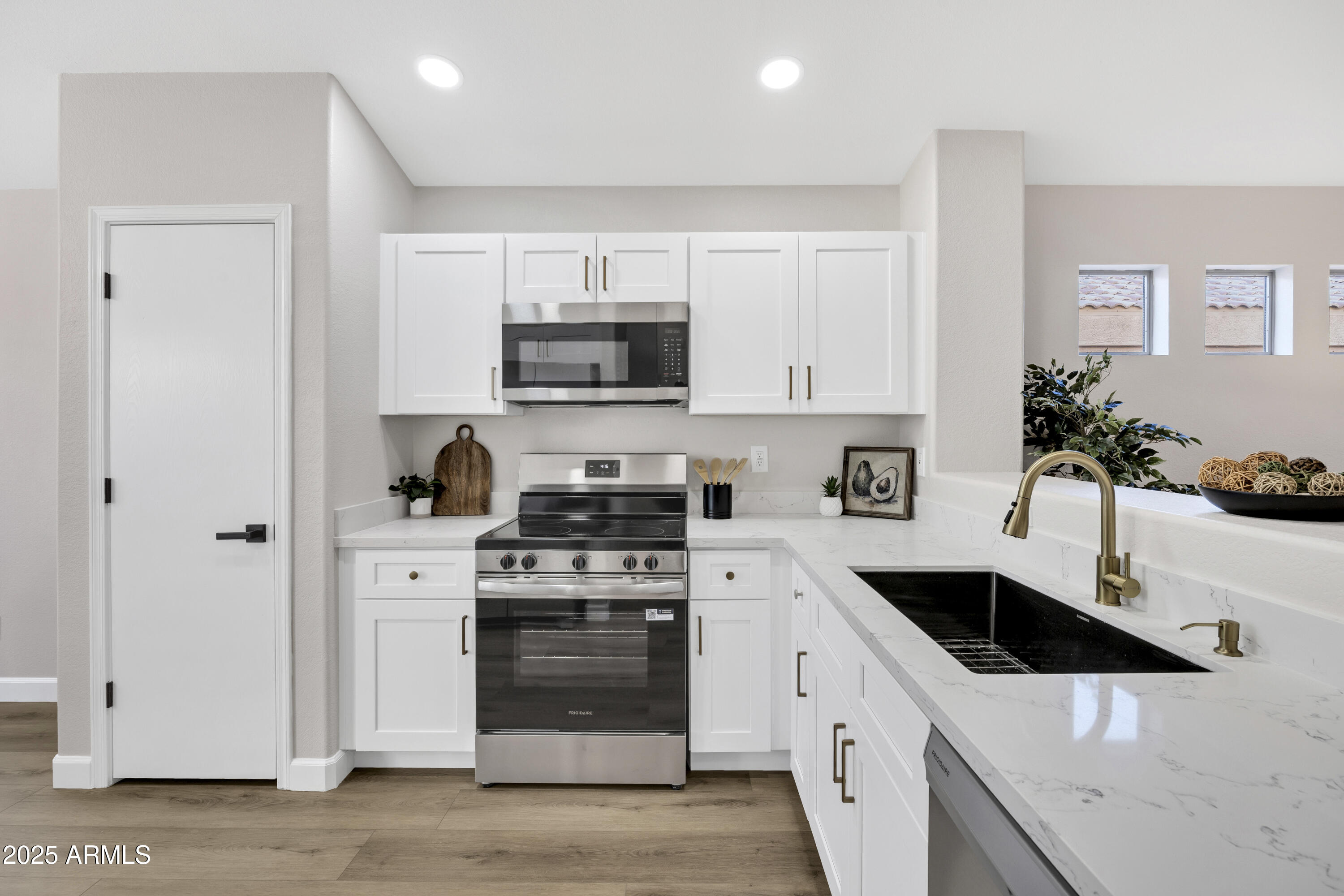 1228 West Diamond Avenue Apache Junction, AZ 85120 - Photo 9 of 25 a kitchen with stainless steel appliances white cabinets a sink a stove and a refrigerator
