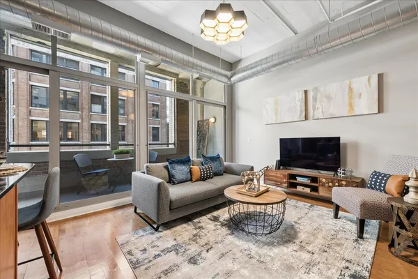 a living room with furniture a rug and a flat screen tv