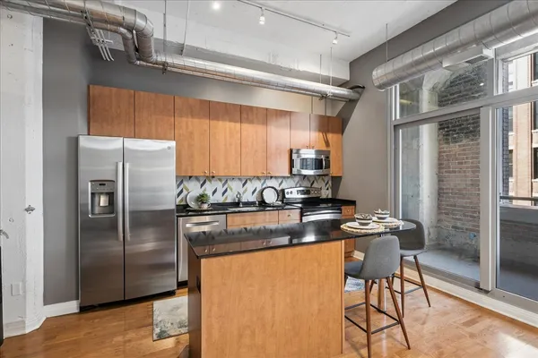 a kitchen with stainless steel appliances granite countertop a refrigerator and a stove