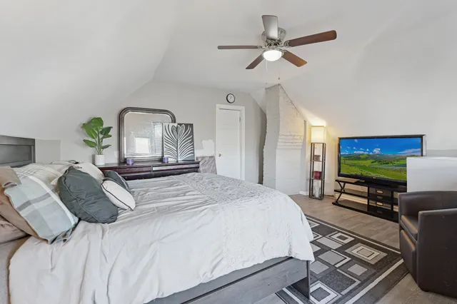 a bedroom with a large bed a flat screen tv and a window